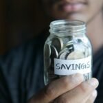 close up shot of a person holding a jar with coins